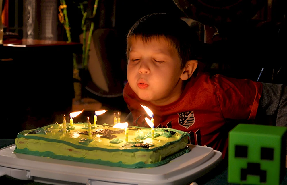 Ребенок задувает свечи на торте